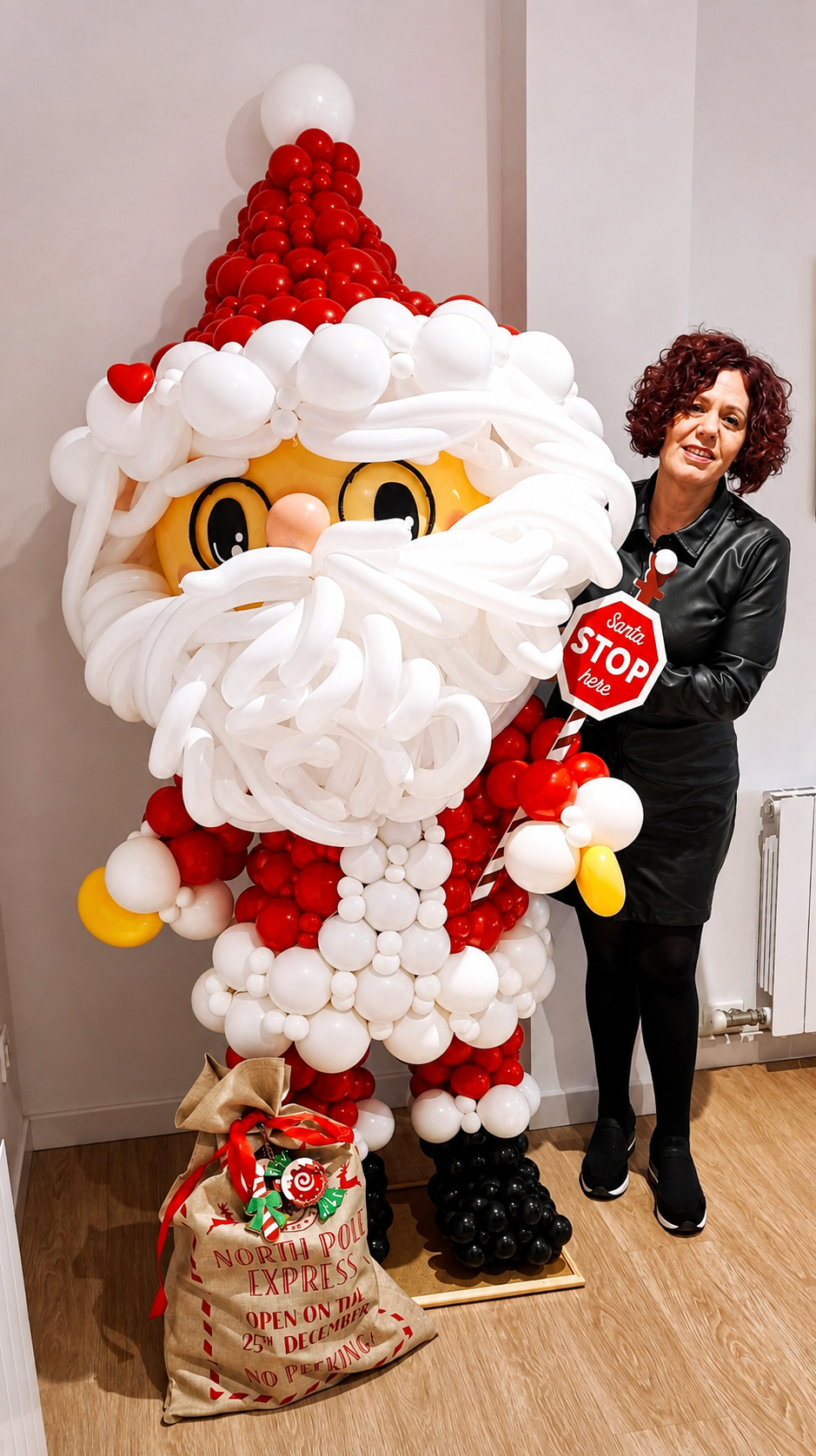 Beatriz junto a una figura de Papá Noel creada con globos